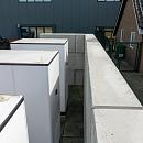 Betonblokken geplaatst rondom installaties naast bedrijfspand voor veilige en afgeschermde opstelling
