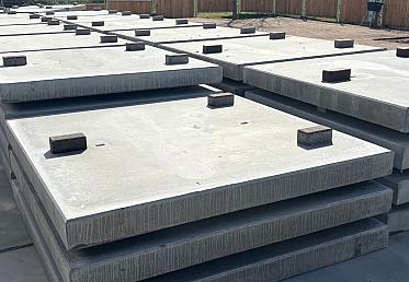 Gestapelde betonplaten op bouwterrein met afstandhouders klaar voor transport en plaatsing